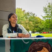 Student working a booth during Student Small Business Market.